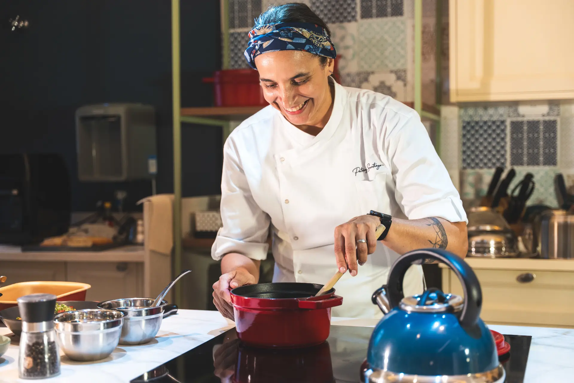 Patricya Santiago, chef de cozinha, ao lado de refeições personalizadas preparadas em sua cozinha.
